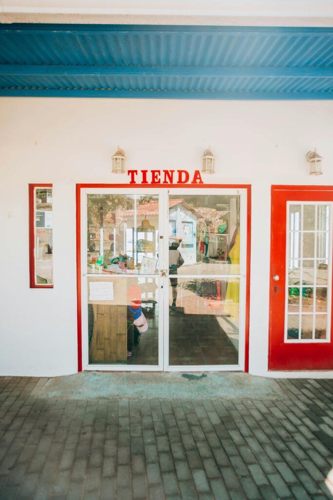 Charming storefront with red doors and glass entry, featuring TIENDA sign.